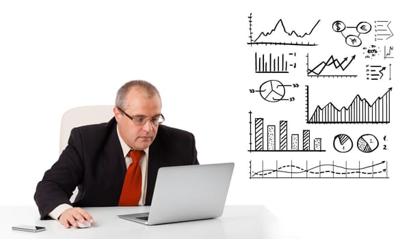 Businessman sitting at desk with diagrams and laptop, isolated on white