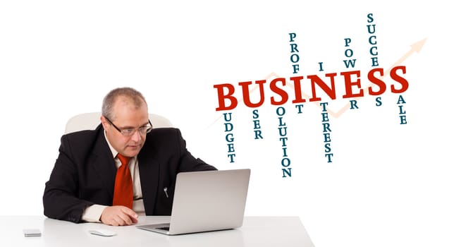 bisinessman sitting at desk and looking laptop with business word cloud, isolated on white