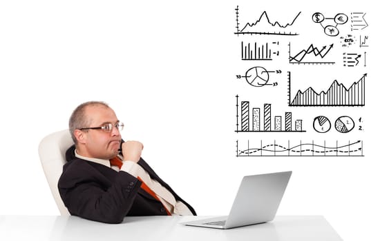 businessman sitting at desk with graphs and laptop, isolated on white