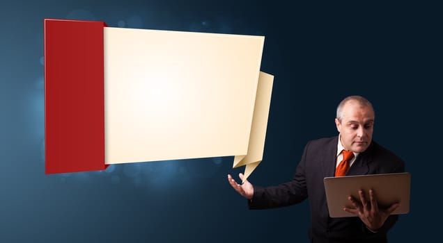 Businessman in suit holding a laptop and presenting modern origami copy space