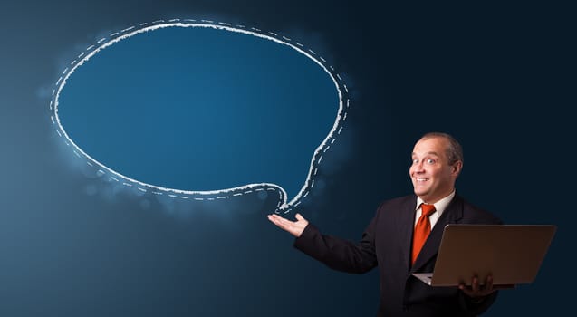 funny businessman in suit holding a laptop and presenting speech bubble copy space