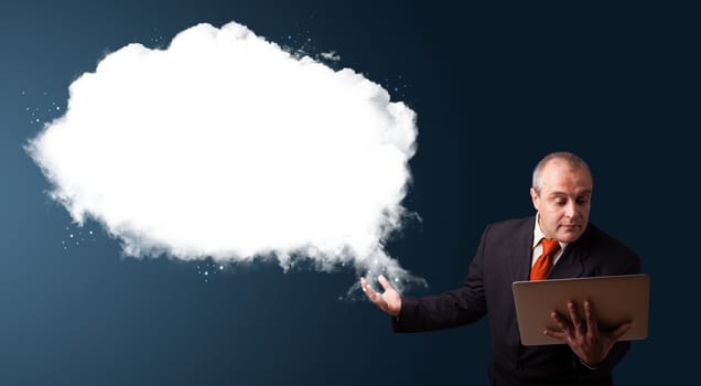 Businessman in suit holding a laptop and presenting abstract cloud copy space
