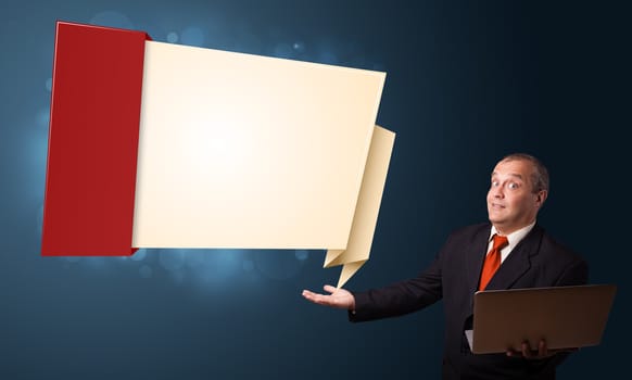 Businessman in suit holding a laptop and presenting modern origami copy space
