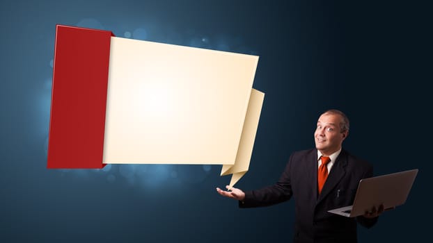 Businessman in suit holding a laptop and presenting modern origami copy space