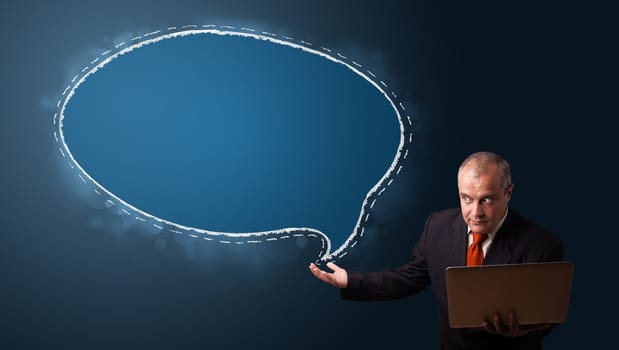 funny businessman in suit holding a laptop and presenting speech bubble copy space