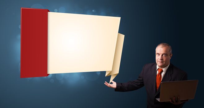 Businessman in suit holding a laptop and presenting modern origami copy space
