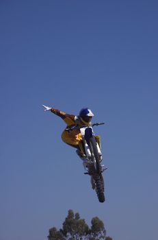 Moto X Freestyle rider high in sky with arms outstretched