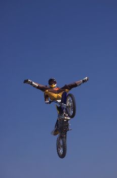 Moto X Freestyle rider with legs open trick high in sky