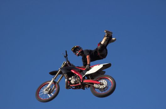 Moto X Freestyle rider high in sky with legs in air