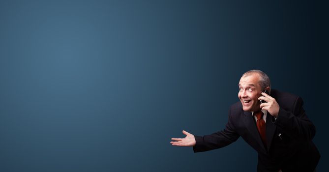crazy businessman in suit holding a phone and presenting copy space