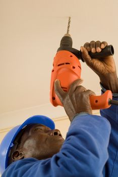 African American Construction Worker, Handyman, Carpenter, Drilling with Electrical Power Tool