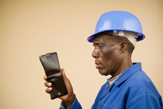 Portrait of construction worker staring at an empty wallet