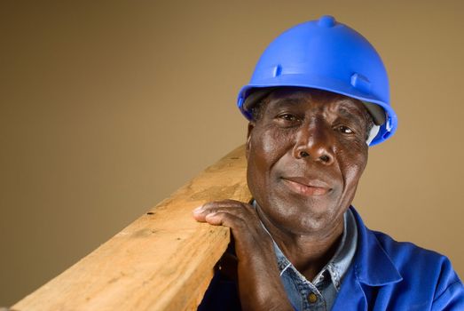 Senior South African or American plumber, carpenter or builder with wooden planks
