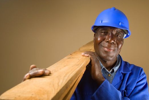 Senior South African or American plumber, carpenter or builder with wooden planks