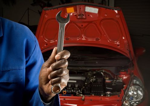 South African or American mechanic with spanner in front of car service engine maintenance