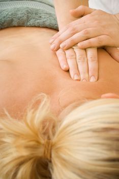 Beauty therapist hands performing spa back massage