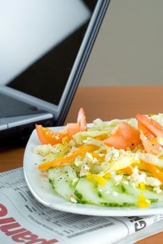 Office business lunch food salad, laptop and financial newspaper on office desk