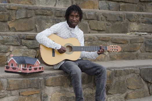 African busker in Howick, KwaZulu-Natal with ethnic model house collecting money