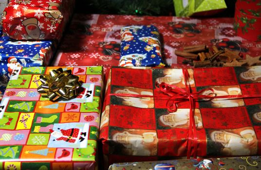 Lot of Christmas gifts wrapped in the beautiful vivid paper 
