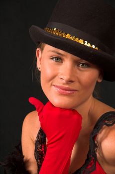 Moulin Rouge model with hat and red gloves holding hat on head with gold band and red gloves on chin and thumb