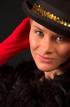 Moulin Rouge model with hat and red gloves holding hat on head with gold band and red gloves behind head