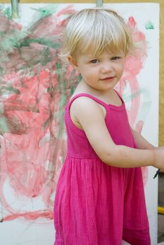 Baby little girl playing with paint artist