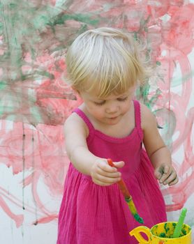 Baby little girl playing with paint artist