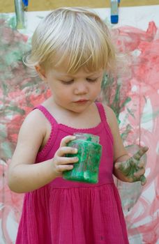 Baby little girl playing with paint artist