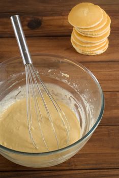 Pancake or flapjack mixture batter with cakes in background