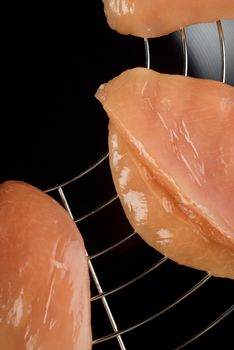Raw chicken fillets on top of wok ready for stir fry