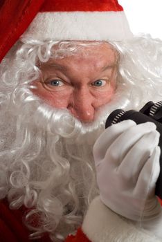 Close up Father Christmas with a jolly look in his eye and binoculars