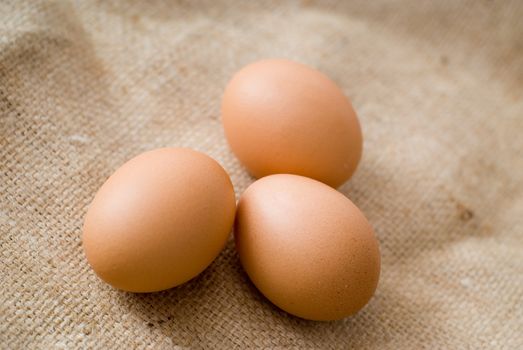 Three farm breakfast eggs on hessian background - landscape orientation