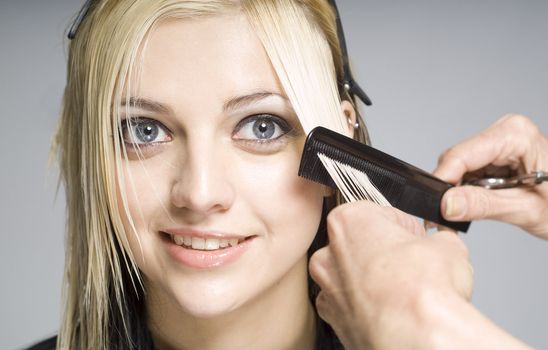 Hairdresser cutting client or customer with comb