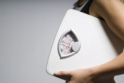 Diet or dieting scale concept held by slim, healthy or trim woman close up