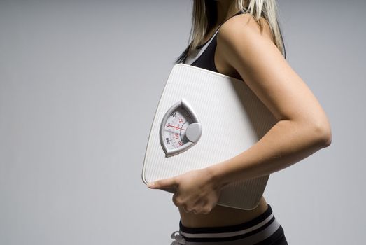 Diet or dieting scale concept held by slim, healthy or trim woman