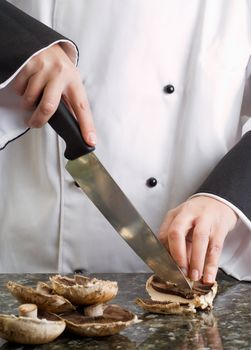 Chef Wearing Black and White Uniform Slicing Brown Mushrooms