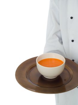 Professional chef in workwear jacket serving soup isoltated on white