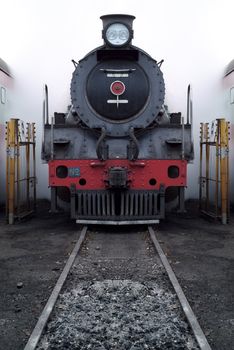 Old vinage steam train with steam and smoke in shunting yard