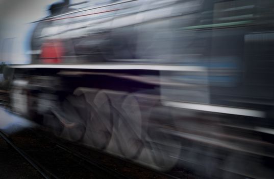 Classic vinatage steam train racing passed with motion blur