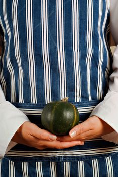 Female woman vegitarian chef or cook holding squash vegetable in her hands