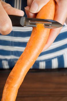 Woman or female cook or chef peeling carrot