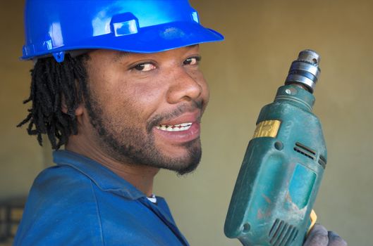 Smiling construction worker with power tool drill