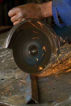 South or African American working with angle grinder