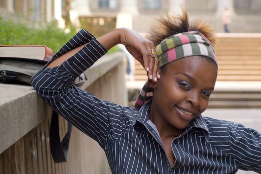 African American college student on campus with book and bag