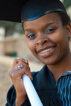 African American college student graduating with mortarboard and diploma or scroll