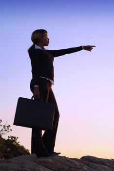 Silhouette of African American Business Woman Standing with Outstretched Arm on Hill Top