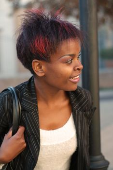 African American businesswoman portrait - looking to the left while waiting for public transport bus at stop