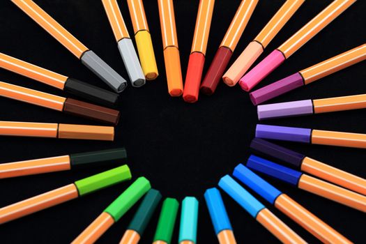 Color Pens in form of love on black background