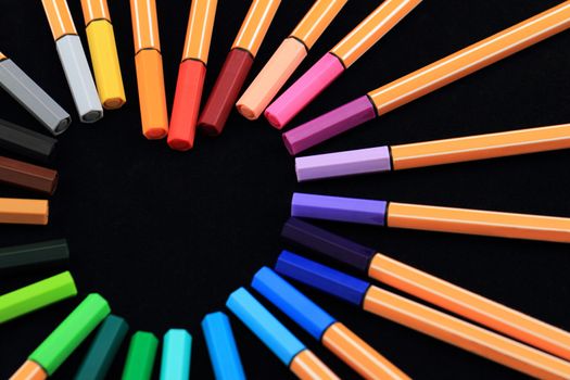 Color Pens in form of love on black background