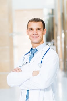 Portrait of a doctor standing in the office and crossed his arms